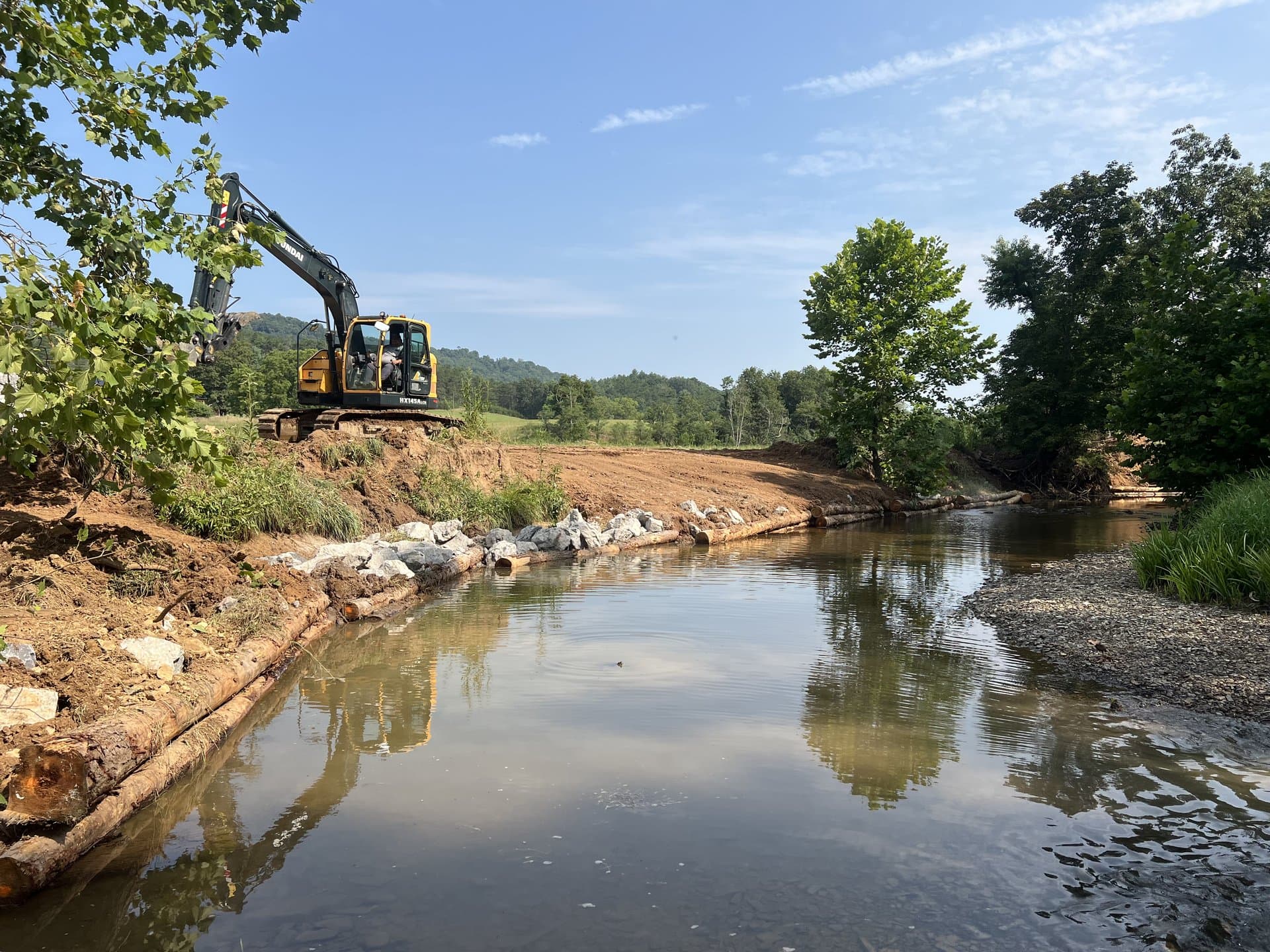 Excavator working a stream restoration channel