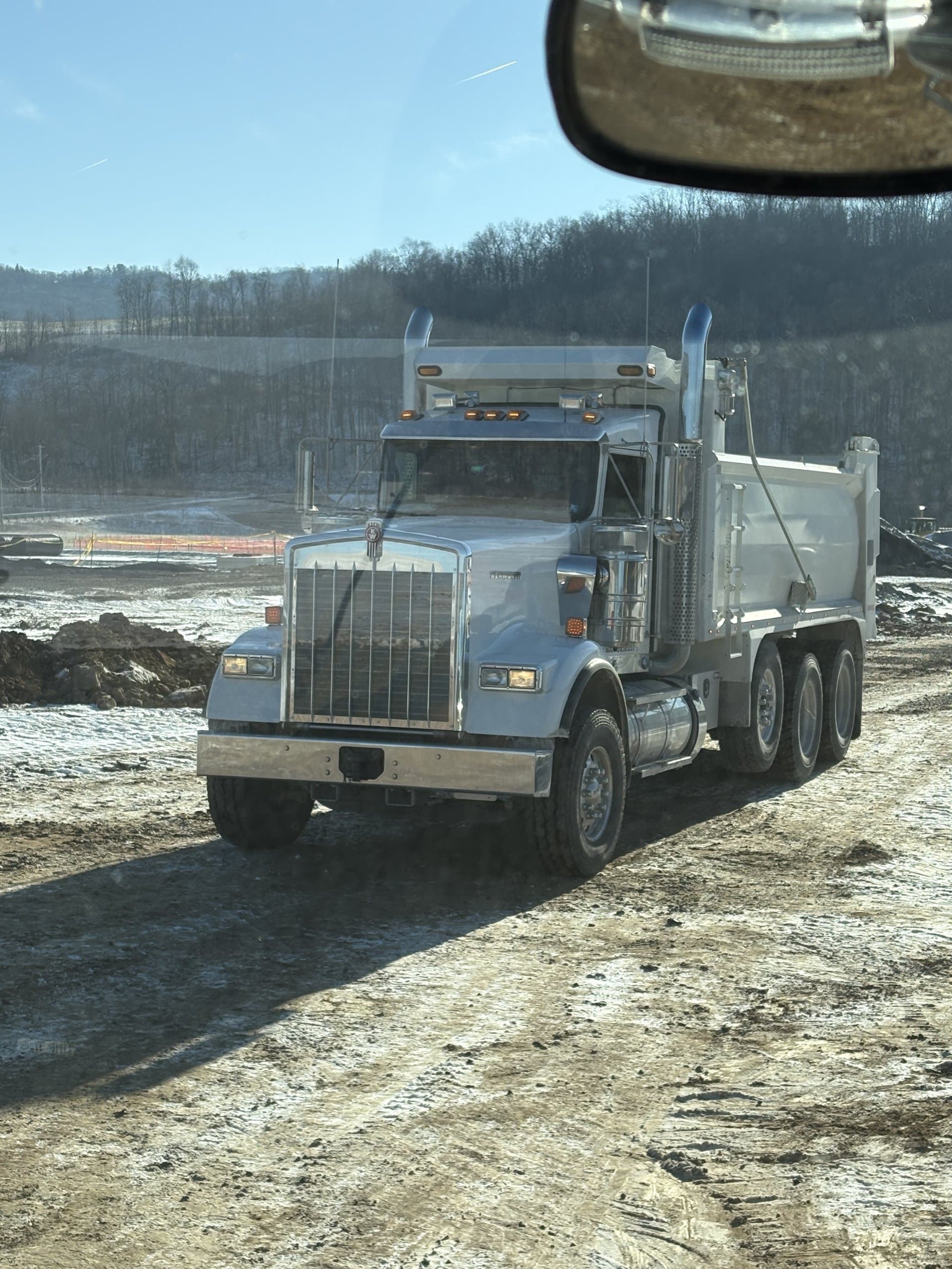 EW Wise Peterbilt dump truck on a wooded job-site access road