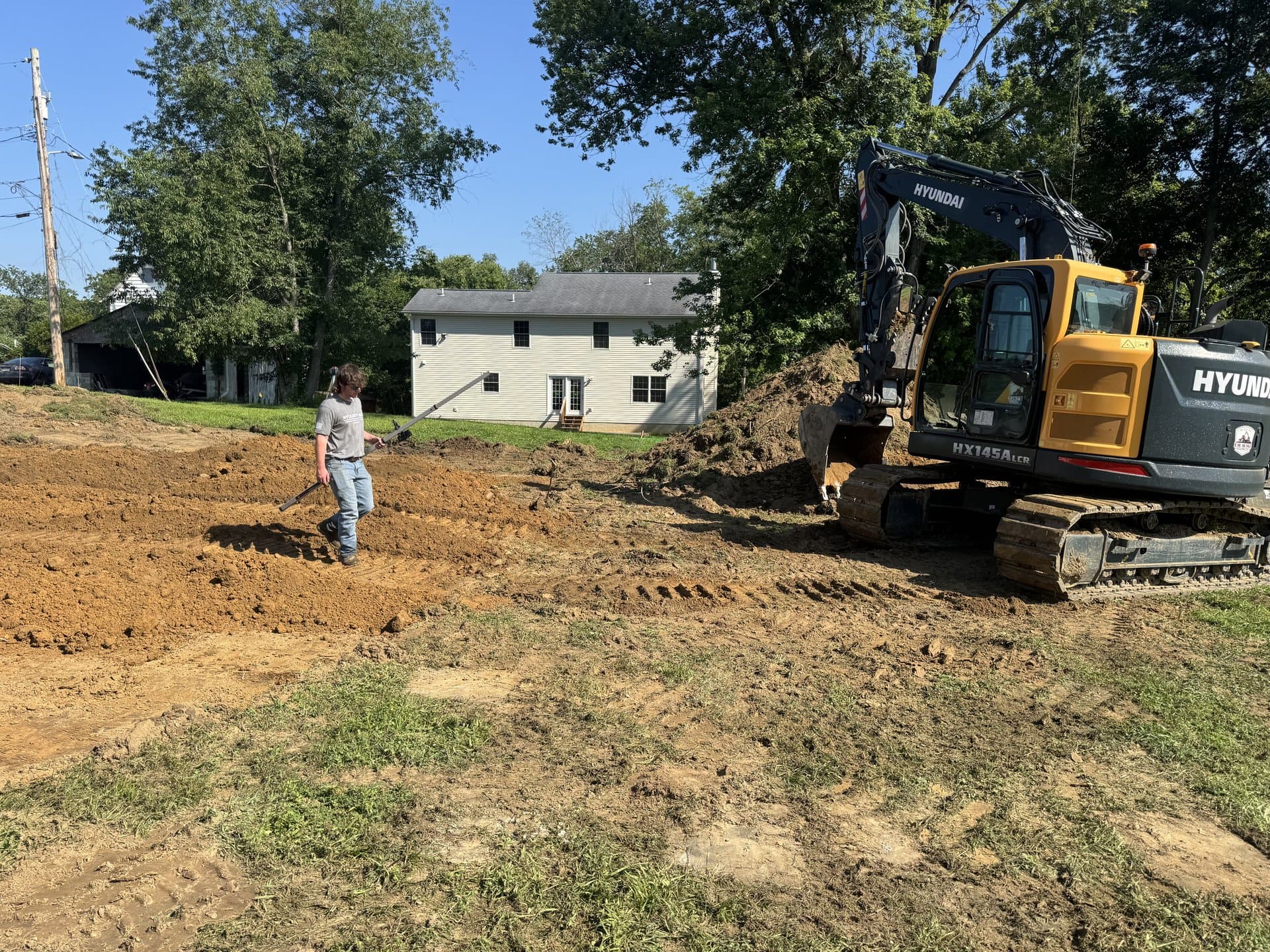 Yellow excavator working a residential excavation cut