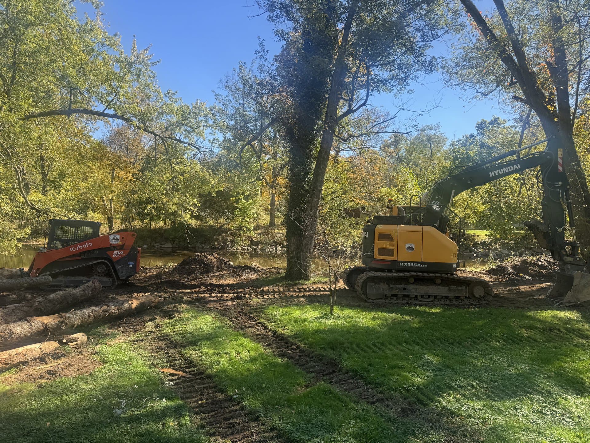 Excavator working a cut in a wooded field