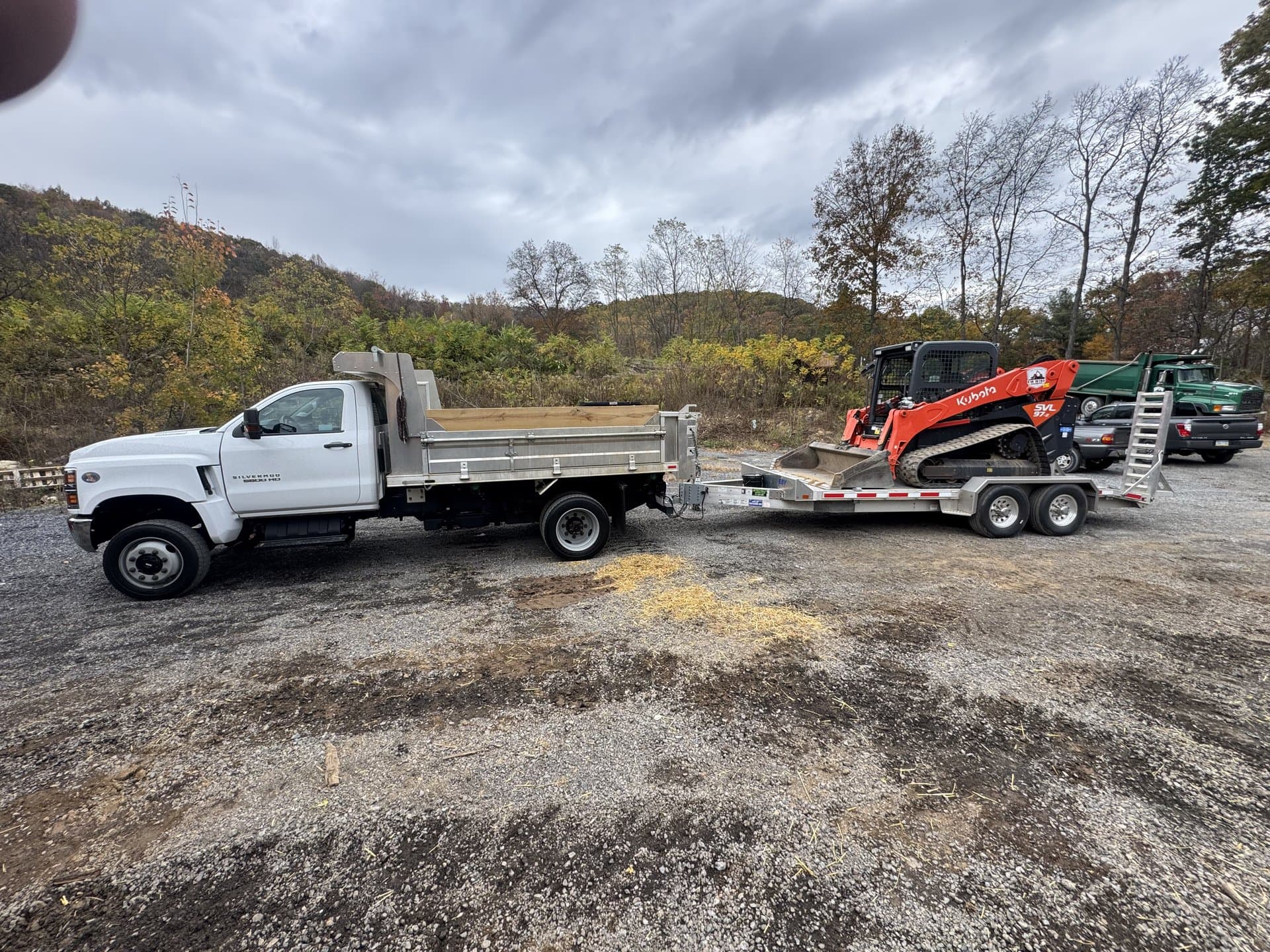 EW Wise dump truck and skid steer working a residential driveway
