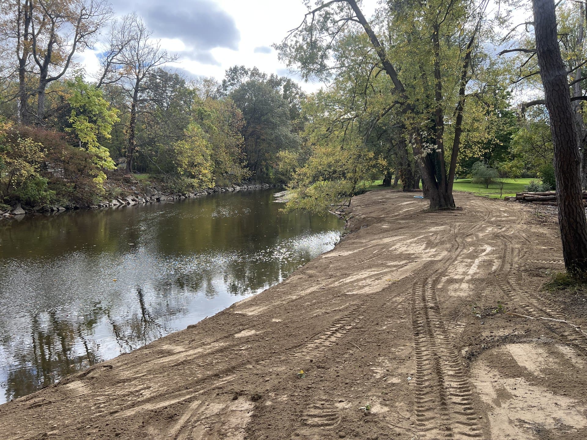 Finished wide stream bank with equipment track marks before the seed takes