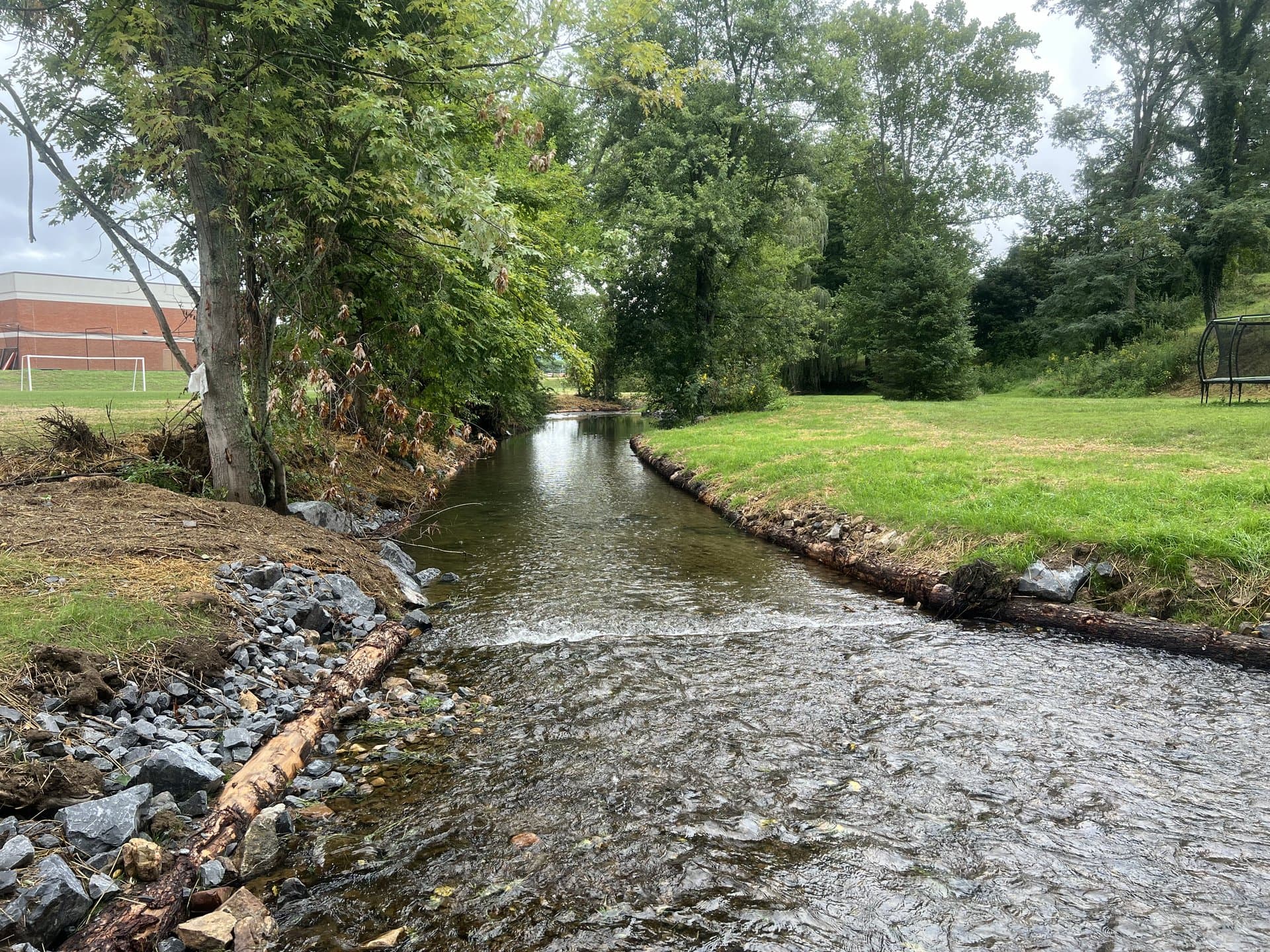 Stream restoration project beside a school with stone armor protecting the bank